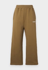 Braune, weit geschnittene Sweatpants mit elastischem Bund und zwei seitlichen Taschen. Auffällige weiße Markenbezeichnung auf der Vorderseite. Aus weichem Baumwollmaterial.