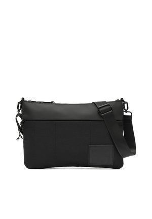 Črni pravokotni torbica čez ramo z nastavljivim trakom, zadrgo za zapiranje in minimalističnim dizajnom z majhno všito značko na sprednjem spodnjem desnem delu.