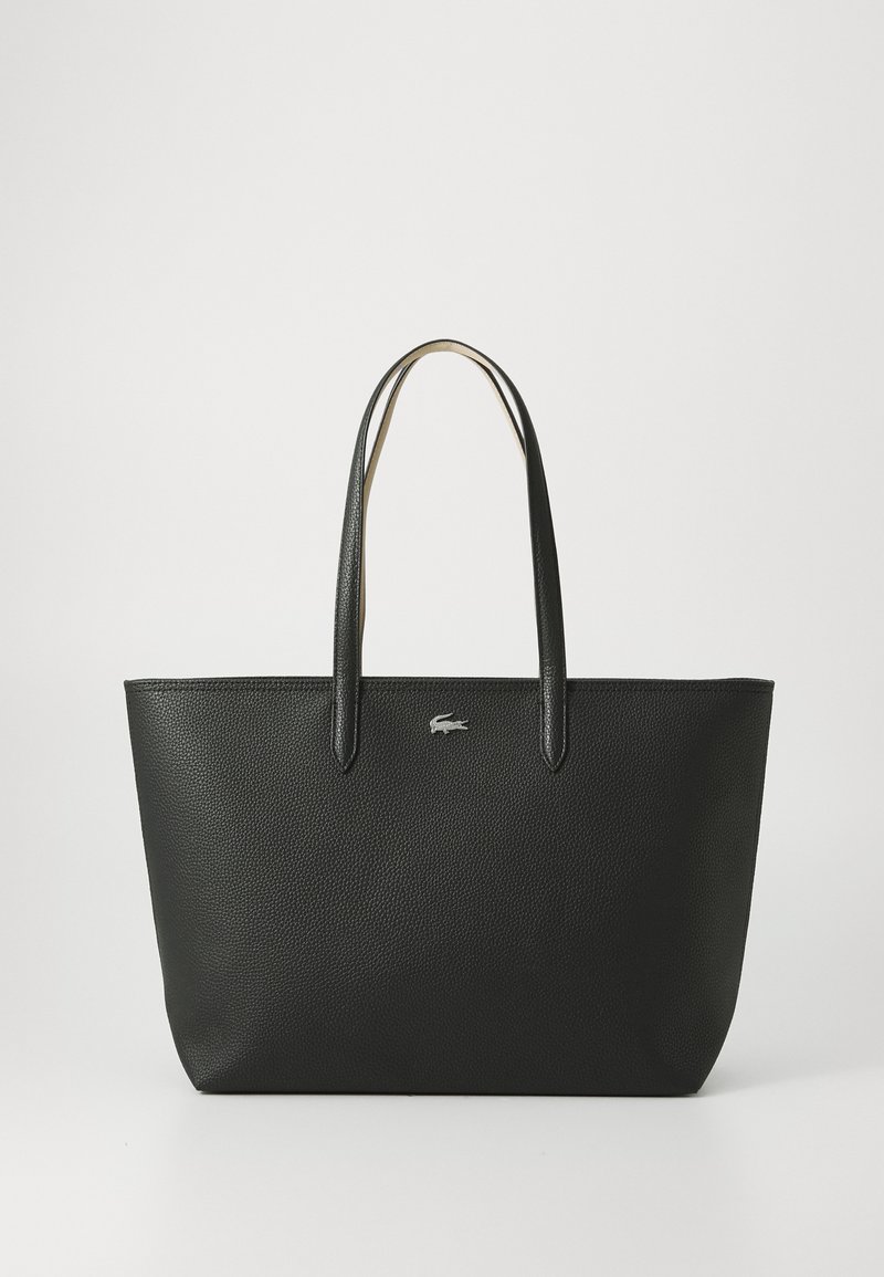 Sac fourre-tout en cuir noir avec une finition texturée, deux poignées et un petit logo argenté à l'avant. Design simple et rectangulaire.