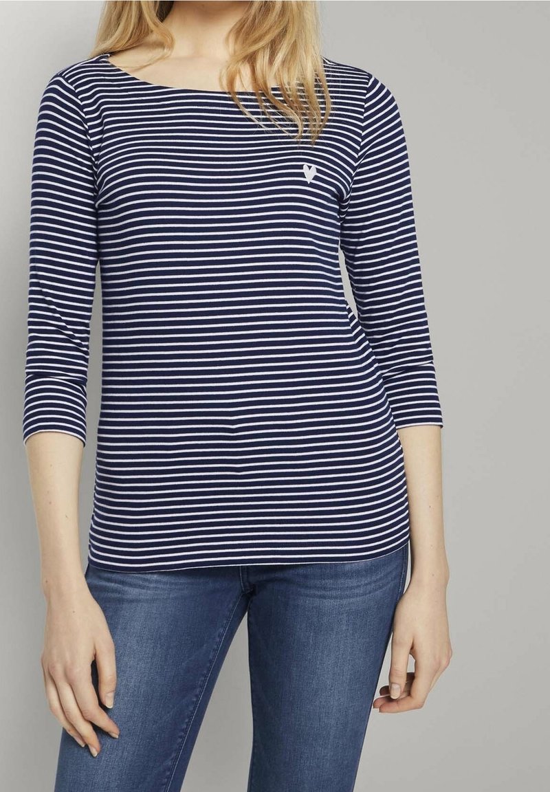 Navy and white striped long-sleeve top with a boat neckline and a small white logo on the chest. Soft fabric with a fitted design.