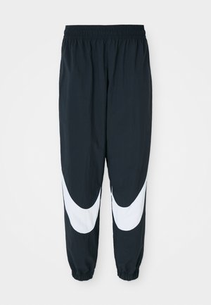 Black track pants with white curved panels, elastic waistband, and gathered cuffs, featuring lightweight fabric and a relaxed fit.