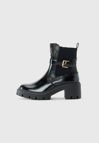 Botte en cuir noir avec semelle en caoutchouc épaisse, talon bloc, panneau latéral élastique, motif embossé décoratif et sangle à boucle dorée.