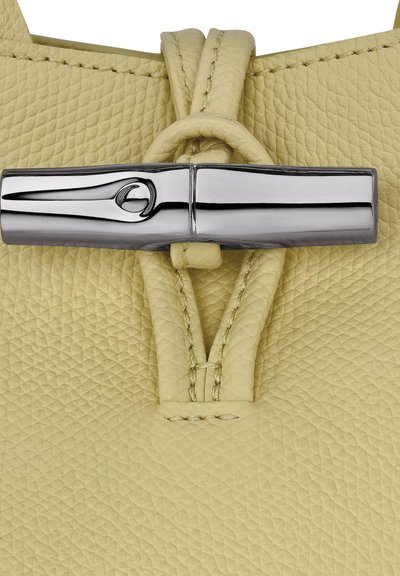 Yellow textured leather bag featuring a metallic silver clasp with a sleek design and a knotted leather detail at the closure.
