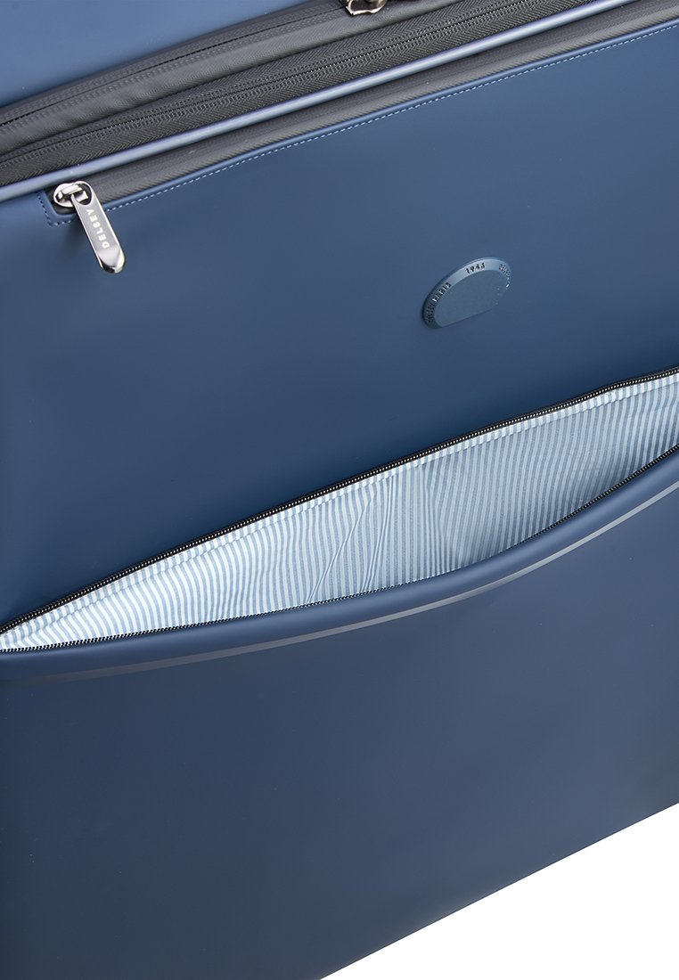 Blauer synthetischer Reisetasche mit Reißverschluss, ausgestattet mit einem gestreiften Innenfutter und einer glatten Außenoberfläche.
