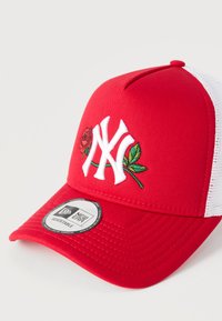 Κόκκινο σκουφάκι snapback με λευκές διχτυωτές πλευρές· διαθέτει κεντημένο λογότυπο NY με σχέδιο τριαντάφυλλου και φύλλου. Ρυθμιζόμενο λουρί· κατασκευασμένο από ύφασμα και δίχτυ.