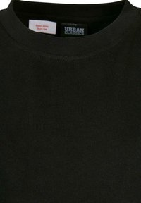 T-shirt noir en coton à col rond avec une texture lisse ; comporte des étiquettes indiquant les instructions d'entretien et le nom de marque "URBAN CLASSICS."