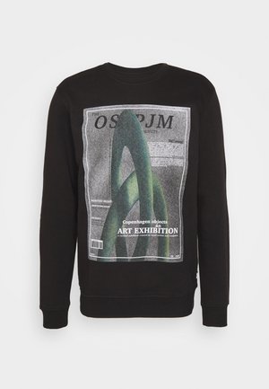 Sweatshirt noir en coton avec un motif graphique de formes vertes entrelacées et un texte concernant une exposition d'art.