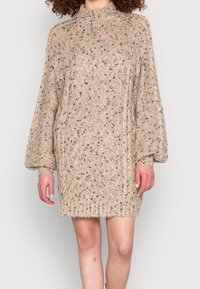 Strickkleid in Beige mit strukturiertem Muster. Verfügt über lange, leicht gepuffte Ärmel und einen gerippten Saum. Weiches, kuscheliges Material.