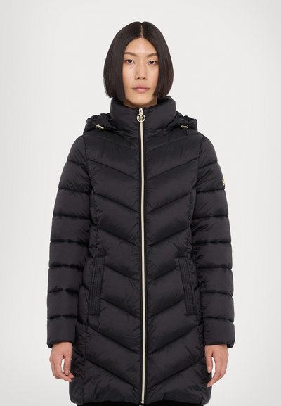 Manteau en duvet noir avec un col haut, une fermeture éclair à l'avant et un motif en chevrons. Comprend des poches à fermeture éclair et des accents en métal doré.