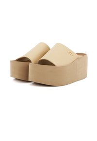 Mule beige con zeppa piatta e punta aperta, in pelle liscia. Suola spessa e solida con finitura opaca e logo discreto sul lato.