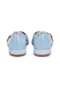 Lichtblauwe leren schoenen met een ronde vorm, voorzien van een schuif en gespsluiting. De zolen zijn bruin, met een vleugje rode accent aan de achterkant.