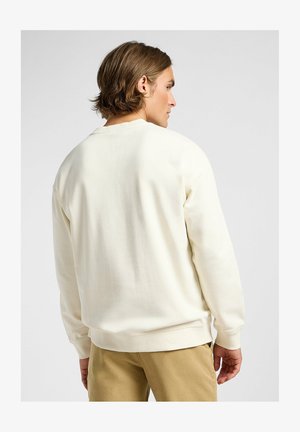 Cremfarbener Sweatshirt mit Rundhalsausschnitt und langen Ärmeln. Weicher Stoff mit glatter Textur. Gerippte Bündchen und Saum, minimalistisches Design.