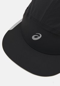Casquette de course noire en tissu léger, dotée d'un visière souple et d'un logo réfléchi à l'avant. Texture lisse, design aérodynamique.