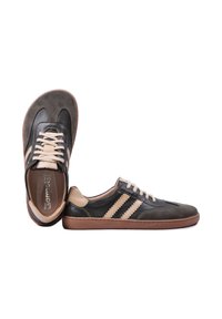 Baskets basses marron et noires avec des rayures et des lacets beiges, présentées avec une chaussure droite et l'autre sur le côté.