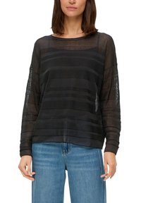 Haut noir à manches longues avec une texture rayée transparente, un col arrondi et une coupe décontractée. Associé à un jean large bleu clair.