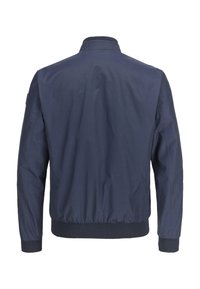 Marineblaue Bomberjacke mit elastischen Bündchen und Saum, glatter Textur und minimalistischem Design ohne sichtbare Beschläge oder Muster.