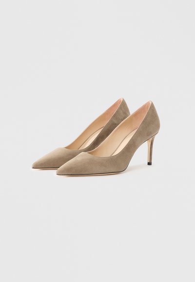 Beige suede high heels with pointed toes and thin heels. Features a smooth texture and minimalistic design. No visible hardware or patterns.