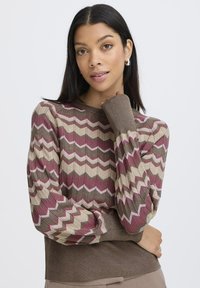 Strickpullover mit einem Zickzackmuster in Burgunder, Creme und Brauntönen. Gerippter Halsausschnitt und Bündchen mit taillierter Passform.