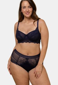 Soutien-gorge en dentelle bleu marine et ensemble de briefs assortis comprenant des panneaux en tulle transparent, des détails festonnés et un nœud décoratif sur le soutien-gorge.