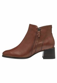 Bottine en cuir marron avec un bout pointu et un talon bloc de hauteur intermédiaire. Elle possède une fermeture éclair sur le côté et des détails de couture subtils.