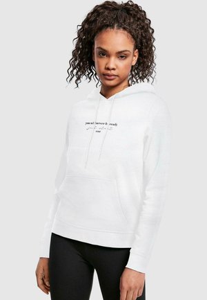 White hoodie in a relaxed fit, featuring a front pocket and graphic text design on the chest. Material appears soft and smooth.
