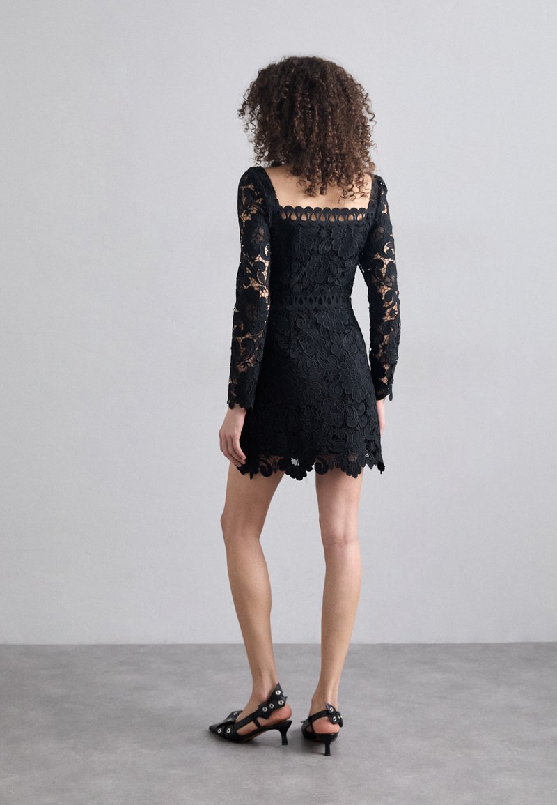 Czarna koronkowa sukienka ma długie rękawy, kwadratowy dekolt oraz falbaniasty dół, z kwiatowymi wzorami i dopasowaną sylwetką.