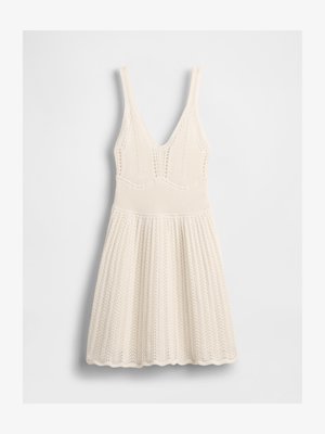 Cream-colored knitted sleeveless dress with V-neck, fitted ribbed waist, and patterned flared skirt on white background.