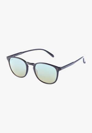 Lunettes de soleil en plastique noir avec des verres teintés en vert, forme ronde, design minimaliste et protection UV400. Elles présentent une texture lisse et des branches solides.
