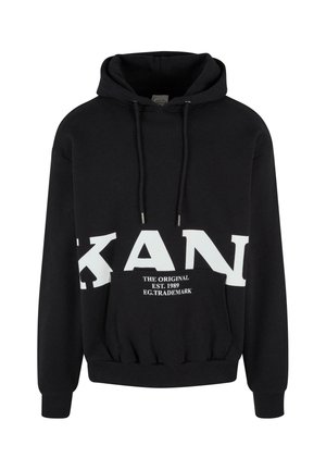 Black hoodie with a kangaroo pocket, featuring a large white logo across the chest and drawstrings with silver tips. Soft fabric texture.