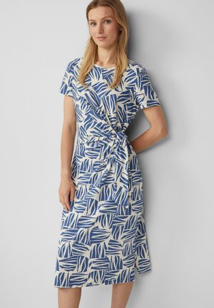 Blauwe en witte jurk met een patroon, korte mouwen, wikkelontwerp en een strikdetail in de taille. Gemaakt van een soepele, lichte stof.