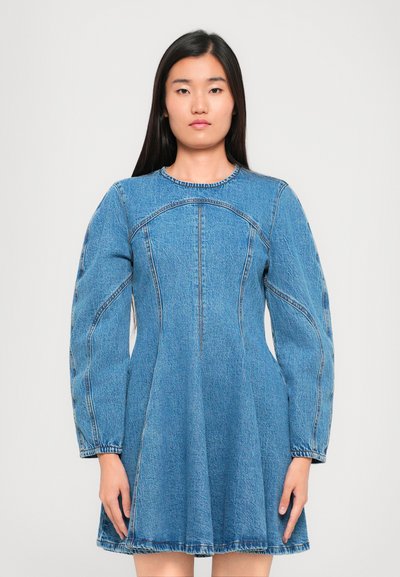 Robe en denim avec des manches bouffantes longues, un col rond, un corsage ajusté, une jupe évasée et des coutures contrastantes, dans une couleur bleu moyen.