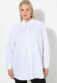 Witte lange mouwen overhemd met knoopsluiting, voorzien van een spitse kraag en een recht model. Gemaakt van soepel stof, met zijsplitten en minimale stiksels.
