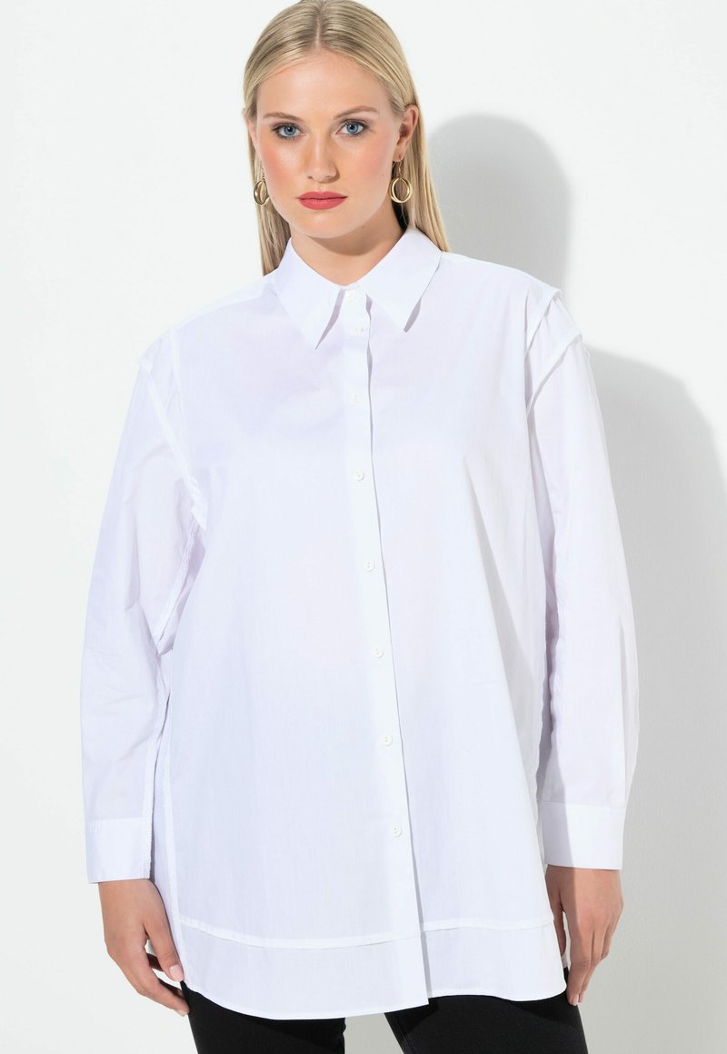 Witte lange mouwen overhemd met knoopsluiting, voorzien van een spitse kraag en een recht model. Gemaakt van soepel stof, met zijsplitten en minimale stiksels.