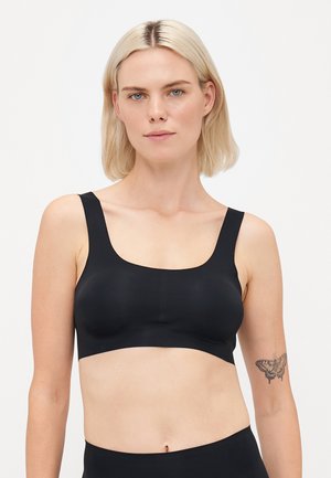 Black bra with wide straps and a scoop neckline. Made from smooth, stretchy fabric, it has a seamless design and minimalistic style.