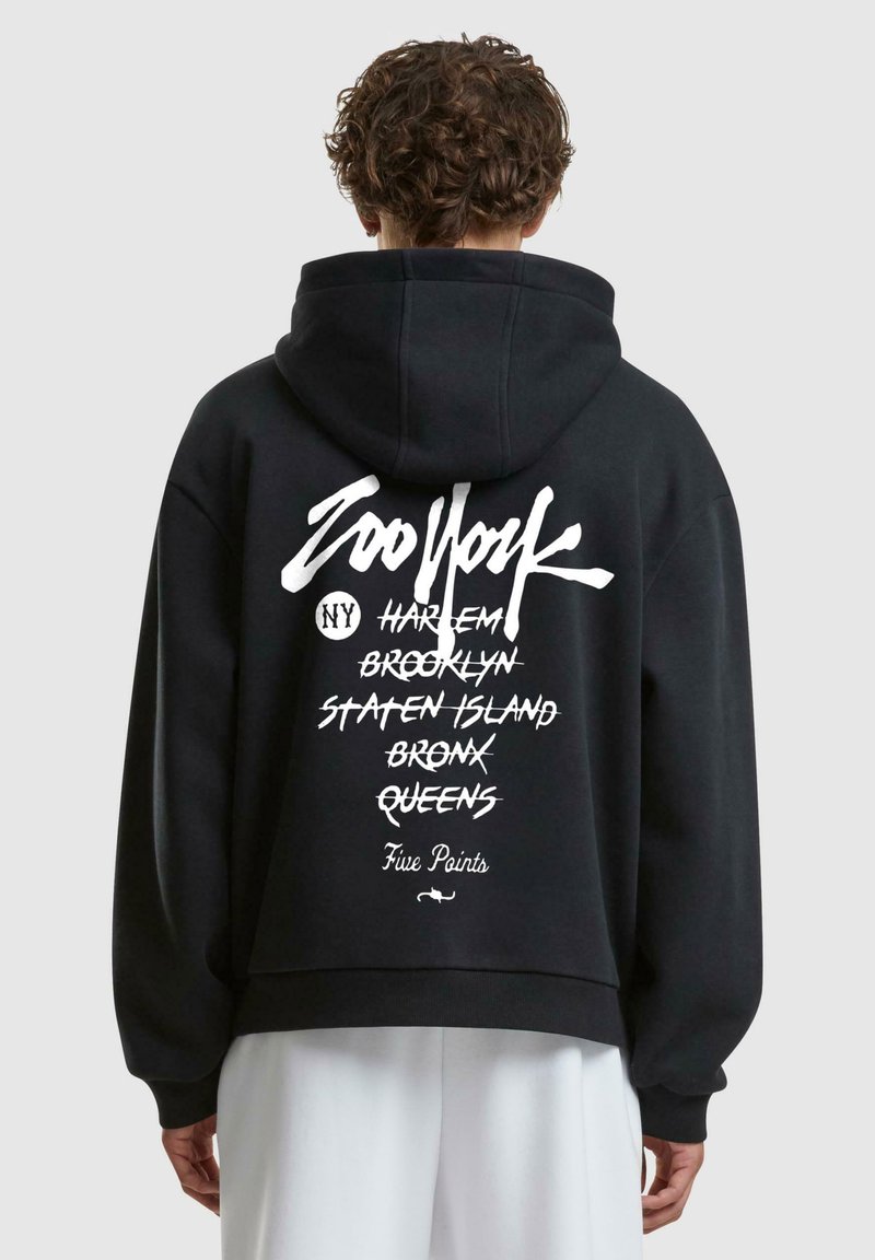 Schwarzer Kapuzenpullover mit einem weißen grafischen Design auf dem Rücken, das verschiedene New Yorker Orte in einer Mischung aus Kursiv- und Fettdruck auflistet.