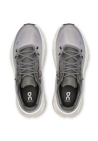 Hallid võrgusilma spordijalatsid tekstuurse pealispinnaga, kontrastsete hallide paeltega, pehmendusega valgete talladega ja sisetalladel logode detailidega.