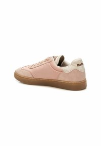 Zapatilla rosa con una parte superior lisa y acentos de ante. Presenta un talón beige, costuras marrones y una suela de goma. Diseño minimalista.