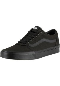 Zapatillas de lona negras con cordones negros, franja lateral gris en contraste, suela de goma y puntera texturizada. Diseño minimalista sin marcas visibles.