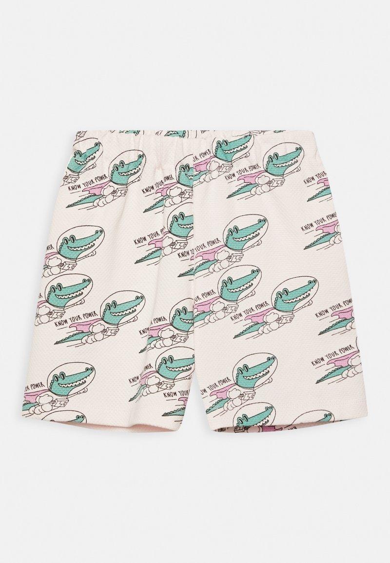 Calças শórt brancas com um padrão divertido de dinossauros em verde e rosa, com o texto "CONHECE A TUA FORÇA", feitas de um tecido texturizado.