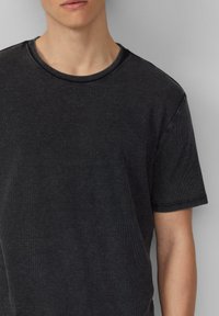 Zwarte geribde T-shirt met een ronde hals en korte mouwen, gemaakt van een textuurstof en met een casual pasvorm.