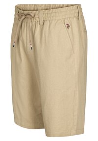 Béžové bavlnené šortky s elastickým pásom a sťahovacou šnúrkou. Obsahujú bočné vrecká a malú vyšívanú nášivku na prednej strane.