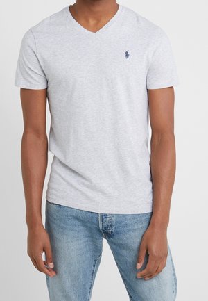 Szara bawełniana koszulka typu v-neck z krótkimi rękawami, z małym granatowym logo na lewej piersi i miękką, gładką fakturą.