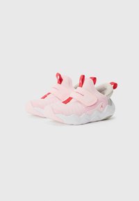 Scarpe da atletica rosa con accenti rossi, caratterizzate da una tomaia in tessuto morbido, cinturino regolabile e una suola bianca ondulata.