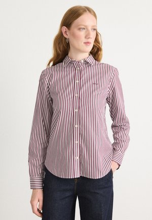 Knappe skjorte med vertikale burgunder- og hvite striper, krage, lange ermer og buet falm. Stoffet ser glatt ut.