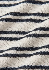 Gestructureerde breistof met horizontale zwarte en witte strepen die zachte golven over het oppervlak vormen.