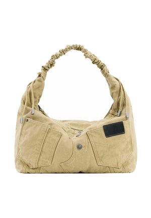 Bolso de tela beige con asa fruncida, bolsillos con solapa frontal, detalle de botón y una pequeña etiqueta negra en el bolsillo derecho.