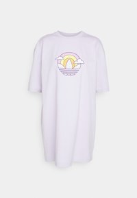 Lila oversized t-shirt med ett tryck av en sol, moln och vågor i gult och lila, tillverkad av mjukt bomullsmaterial.