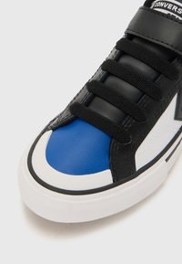 Czarny skórzany tenisówka z niebieskimi i białymi akcentami, o gładkiej fakturze i sześcioma czarnymi oczkami na sznurowadła. Biała gumowa podeszwa.