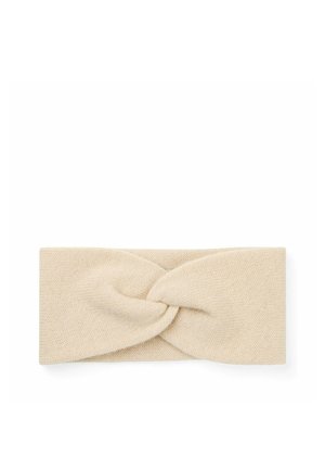 Beige gebreide stoffen haarband met een gedraaid knoopontwerp in het midden, plat gelegd op een witte achtergrond.