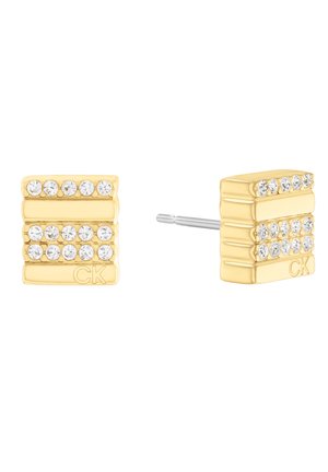 Boucles d'oreilles en métal doré avec trois rangées de cristaux transparents, au design rectangulaire et avec fermoir à tige. Le logo CK est présent d'un côté.